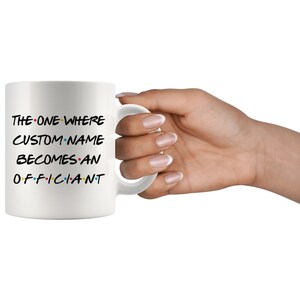 K&ouml;nnte beinhalten: Wei&szlig;e Keramiktasse mit schwarzem Text, der "THE ONE WHERE CUSTOM NAME BECOMES AN OFFICIANT" lautet, mit bunten Punkten zwischen den W&ouml;rtern.