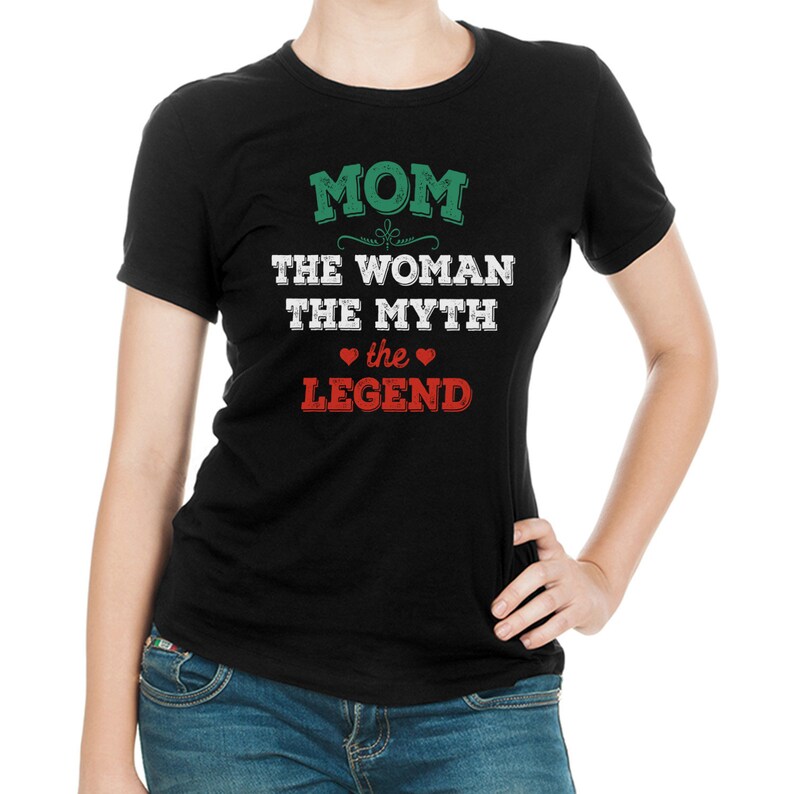 Puede incluir: Camiseta negra con un gr&aacute;fico verde y blanco que dice "MOM THE WOMAN THE MYTH the LEGEND" con dos corazones rojos.