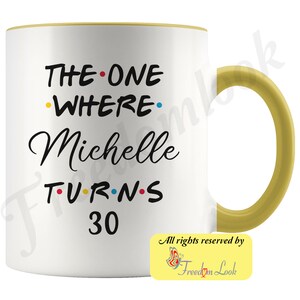 May include: White ceramic mug with a yellow rim and handle. The mug features black text that reads "THE ONE WHERE Michelle TURNS 30" with colorful dots between the words.
