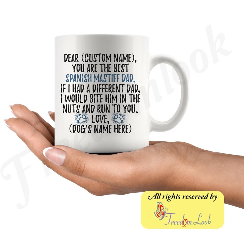 May include: White ceramic coffee mug with a blue and white paw print design. The mug reads "Dear (Custom Name), You are the best Spanish Mastiff Dad. If I had a different dad, I would bite him in the nuts and run to you. Love, (Dog's Name Here)"