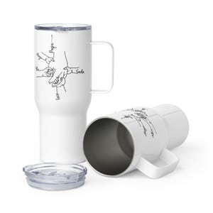 May include: White travel mug with a handle and a clear lid. The mug features a black line drawing of hands and the names "Hugo", "Alex", "Lucie", "Sacha", and "Papa". The second mug is lying on its side.