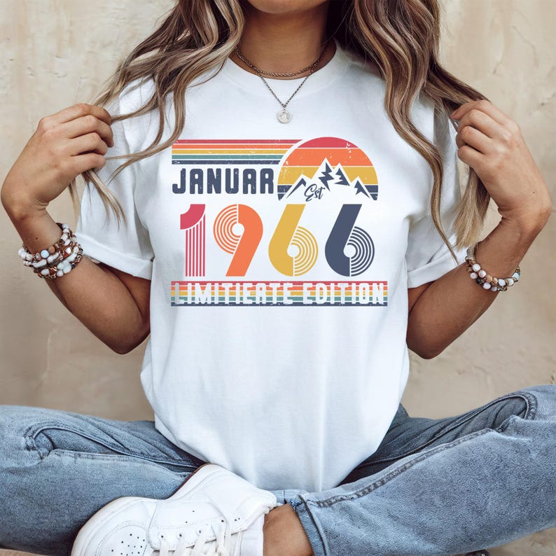 May include: White t-shirt with a retro design featuring the text "JANUARY 1966" in a colorful, vintage font. The design includes a mountain range and a sunset graphic, with the words "LIMITED EDITION" below.