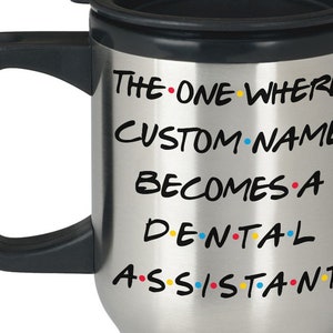 Può includere: Tazza da viaggio in acciaio inossidabile con coperchio e manico neri. La tazza ha il testo "The One Where CUSTOM NAME Becomes A Dental Assistant" con punti colorati.