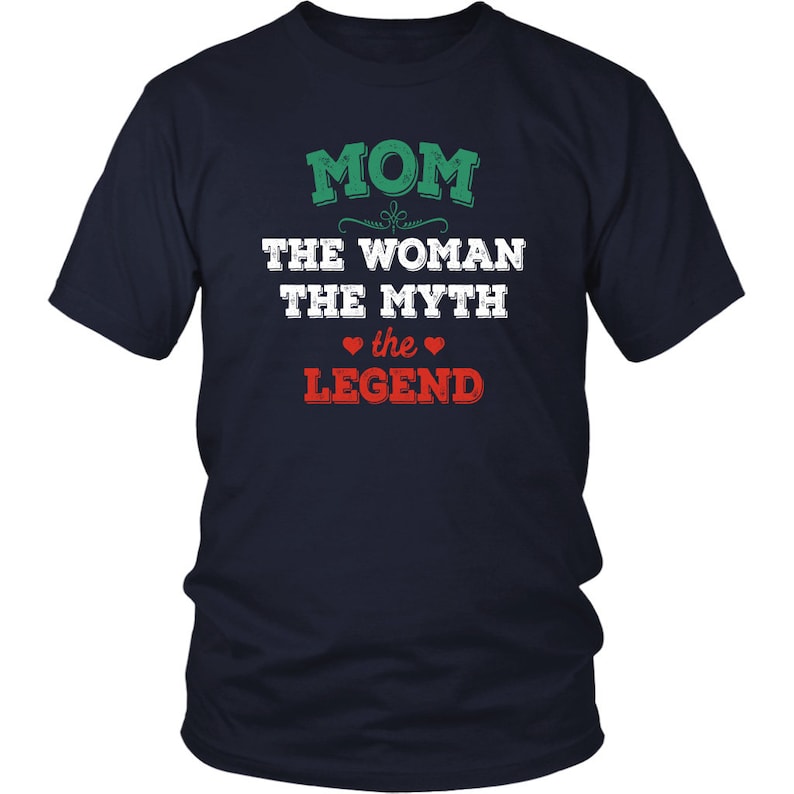 Puede incluir: Camiseta azul marino con texto blanco que dice "MOM THE WOMAN THE MYTH the LEGEND" con un coraz&oacute;n verde a cada lado de la palabra "the".