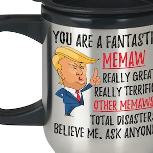 Può includere: Una tazza da viaggio in argento con manico e coperchio neri. La tazza presenta un'immagine di un cartone animato di una persona con i capelli biondi e un abito blu. Il testo sulla tazza recita "You are a fantastic Memaw. Really great. Really terrific. Other Memaws? Total disasters! Believe me, ask anyone."