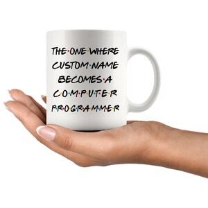 May include: White ceramic mug with black text that reads "The One Where CUSTOM NAME Becomes A Computer Programmer" in a font reminiscent of the popular TV show "Friends".