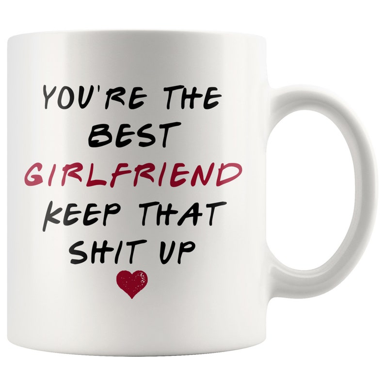 May include: White ceramic coffee mug with black text that reads "You're the best girlfriend keep that sh*t up" with a red heart.