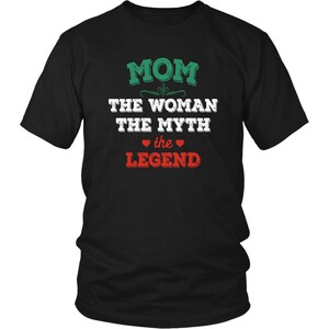 Puede incluir: Camiseta negra con texto blanco que dice "MOM THE WOMAN THE MYTH the LEGEND" con un dise&ntilde;o de remolino verde sobre el texto y dos corazones rojos alrededor de la palabra "the".