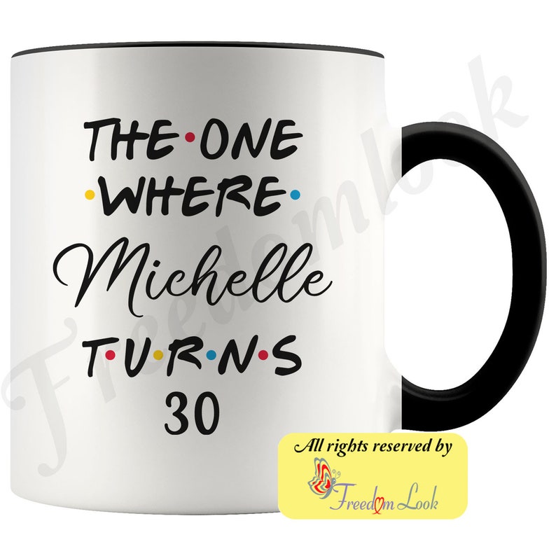 May include: White ceramic mug with a black handle. The mug has black text that reads "THE ONE WHERE Michelle TURNS 30". The text is decorated with colorful dots. The mug has a yellow and white sticker on the bottom right corner that reads "All rights reserved by Freedom Look".