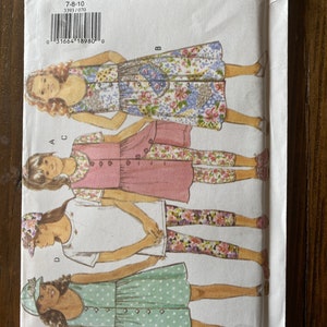 May include: A sewing pattern for girls' clothing, sizes 7-10. The pattern includes a dress, a top, leggings, and a hat. The pattern is from Butterick and the pattern number is 3393.