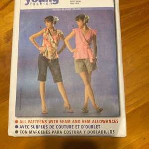 May include: A sewing pattern package featuring a blouse design. The package has the text "burda young fashion" and includes images of the blouse in different colors. The text "ALL PATTERNS WITH SEAM AND HEM ALLOWANCES" is also visible.