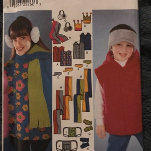 May include: Simplicity sewing pattern featuring children's winter accessories and clothing. The pattern includes designs for scarves, ear muffs, vests, hats, and face masks. The cover shows illustrations of the finished garments and accessories.