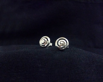 May include: A pair of silver earrings with a spiral design. The earrings are small and delicate, and they would make a great gift for someone special.
