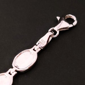 Puede incluir: Pulsera de plata con cierre de langosta y dos eslabones ovalados. El cierre est&aacute; marcado con "925 Sterling".