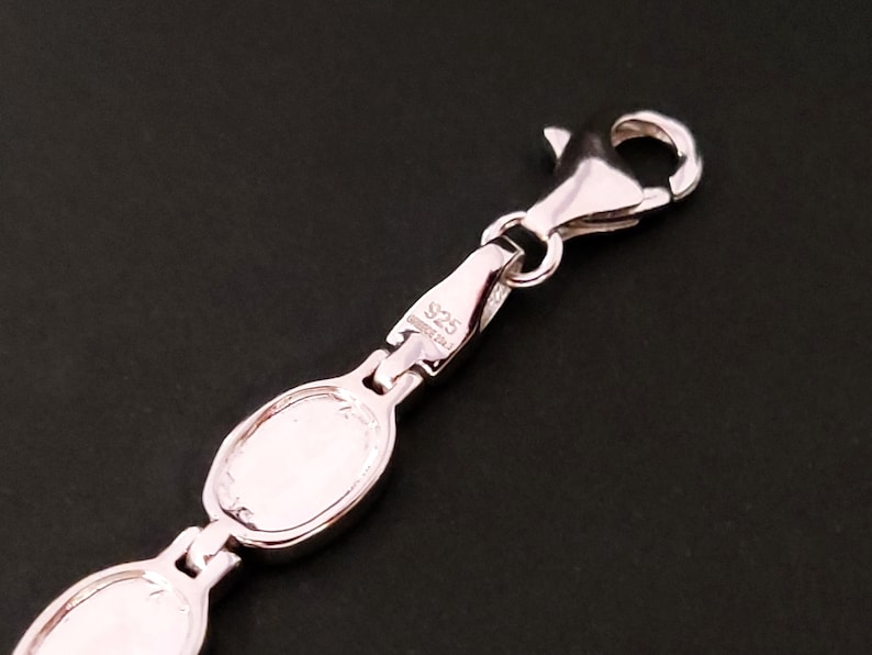 Puede incluir: Pulsera de plata con cierre de langosta y dos eslabones ovalados. El cierre est&aacute; marcado con "925 Sterling".