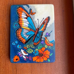 Butterfly Painted Rock SEALED among flowers on Santorini