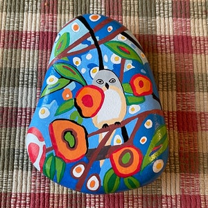 Bird painted rock SEALED among flowers