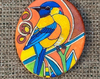 Piedra pintada con pájaros de colores, sellada con oro líquido.