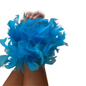 May include: A pair of blue feather wrist cuffs. The cuffs are made of soft, fluffy feathers and are perfect for adding a touch of whimsy to any outfit.