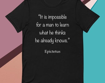 May include: Black t-shirt with the quote "It is impossible for a man to learn what he thinks he already knows." attributed to Epictetus in white text. The shirt is a classic crew neck style.