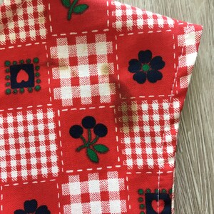 May include: Red and white gingham fabric with a patchwork design featuring blue and green floral and berry motifs.