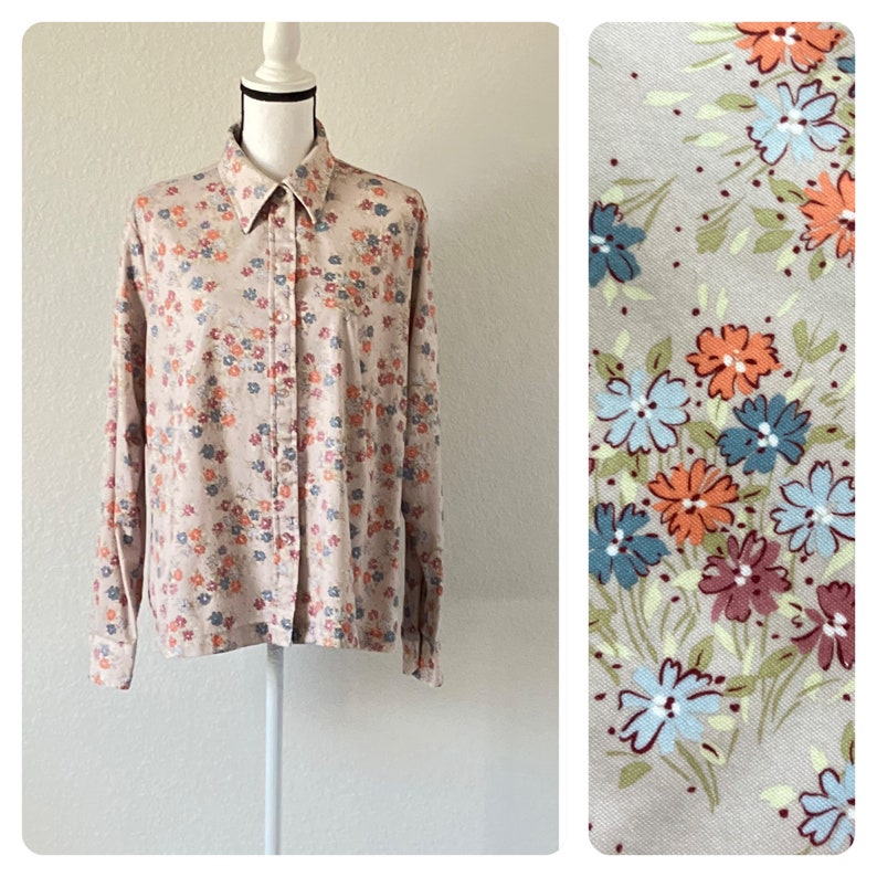 Puede incluir: Una camisa de manga larga con botones y estampado floral en tonos rosa, azul y naranja. La camisa tiene cuello y cierre de botones en la parte delantera.