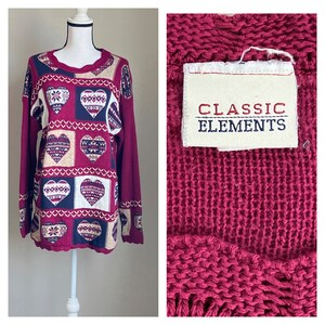 May include: A burgundy sweater with a heart pattern and a white tag that says "Classic Elements".