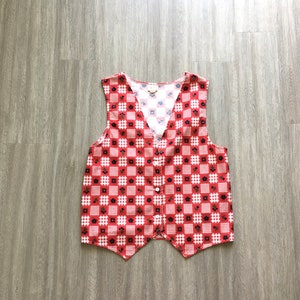 May include: A red and white checkered vest with a floral pattern. The vest has a V-neck and a button closure.