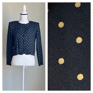 May include: A black cropped cardigan with a scalloped hem and gold polka dots.