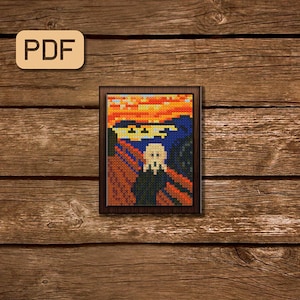 May include: A framed cross-stitch of Edvard Munch's The Scream, a famous painting depicting a figure with a distorted face and hands covering their ears, set against a swirling, orange and yellow sky.