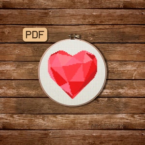 May include: A PDF pattern for a cross stitch design of a red, geometric heart on a white background. The heart is in a wooden embroidery hoop.