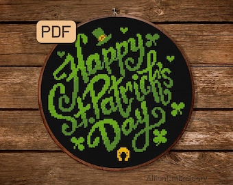 Könnte beinhalten: Ein schwarzer und grüner Kreuzstich-Stickrahmen mit dem Text "Happy St. Patrick's Day" in grüner Kursivschrift. Das Design enthält auch ein Kleeblatt, einen Koboldhut und ein Hufeisen.
