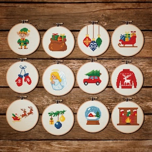 Puede incluir: Una colección de doce aros de bordado de punto de cruz con temática navideña. Cada aro presenta un diseño festivo diferente, que incluye un elfo, regalos, adornos, un trineo, mitones, un ángel, un coche con un árbol, un suéter, renos, una bola de nieve y una chimenea.