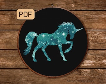 Puede incluir: Un unicornio azul turquesa con un patrón estrellado sobre un fondo negro. El unicornio está de pie sobre sus cuatro patas con la cabeza girada hacia un lado. La imagen está en un aro de bordado redondo.