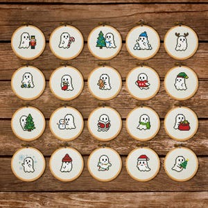 May include: A collection of twenty circular wooden embroidery hoops, each containing a white fabric panel with a unique pixel art ghost design. The ghosts are depicted with various holiday-themed accessories including Christmas trees, candy canes, Santa hats, reindeer antlers, and winter scarves.