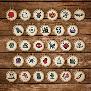 Può includere: Una collezione di piccoli cerchi da ricamo a punto croce rotondi con disegni a tema Halloween. I disegni includono un fantasma, una zucca, una ragnatela, un pipistrello, un teschio e altri motivi spettrali.