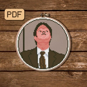 Puede incluir: Un patrón de punto de cruz de un hombre con traje y una expresión seria. El patrón está en un aro de bordado redondo.