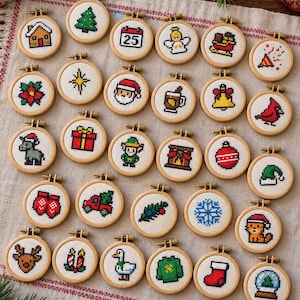 May include: A collection of twenty-five small circular wooden embroidery hoops, each containing a unique cross-stitch design featuring Christmas-themed icons such as a gingerbread house, Santa Claus, a reindeer, a snowflake, and a gift box.