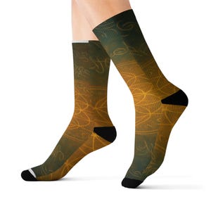 May include: A pair of socks with a gradient design, transitioning from a dark green to a golden yellow. The socks feature an intricate, glowing, golden pattern. The heel and toe are black, and the cuff has a white stripe.