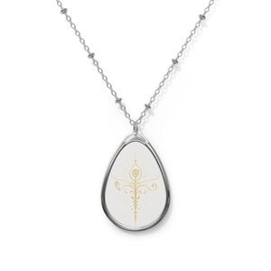 May include: Silver necklace with an oval pendant. The pendant displays a gold-coloured, stylised floral design on a white background. The necklace chain is delicate and has a simple, elegant design. The pendant is approximately 3.8 cm in length.