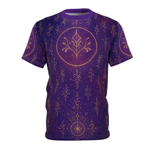 Puede incluir: Camiseta morada con un diseño circular dorado que presenta un patrón estilizado de hojas y ramas. La camiseta tiene un patrón repetido de símbolos dorados y un cuello morado. El diseño general tiene un tema místico o de fantasía.