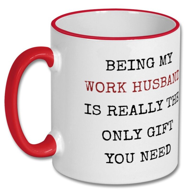 May include: White ceramic mug with a red handle and rim. The mug features the text "BEING MY WORK HUSBAND IS REALLY THE ONLY GIFT YOU NEED" in black and red lettering.