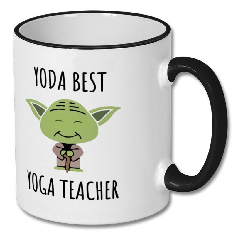 May include: White ceramic mug with a black rim and handle. The mug features a cartoon image of Yoda from Star Wars, with the text "Yoda Best Yoga Teacher".
