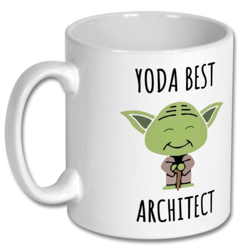 May include: White ceramic coffee mug with a green cartoon character of Yoda from Star Wars. The text "Yoda Best Architect" is printed on the mug.