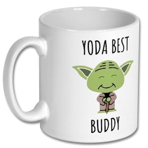 May include: White ceramic coffee mug with a green cartoon Yoda character holding a stick. The text "YODA BEST BUDDY" is printed on the mug.