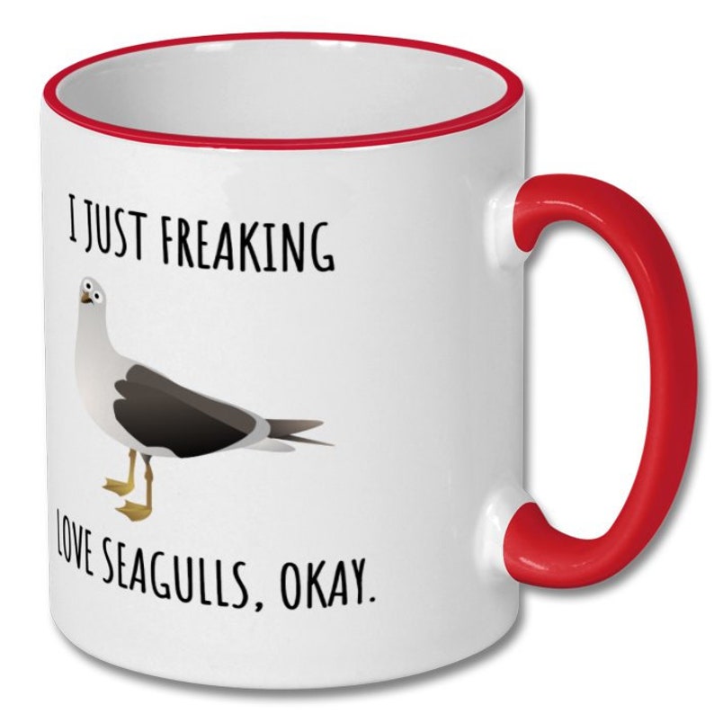 May include: White ceramic coffee mug with a red rim and handle. The mug features a black and white illustration of a seagull and the text "I just freaking love seagulls, okay."