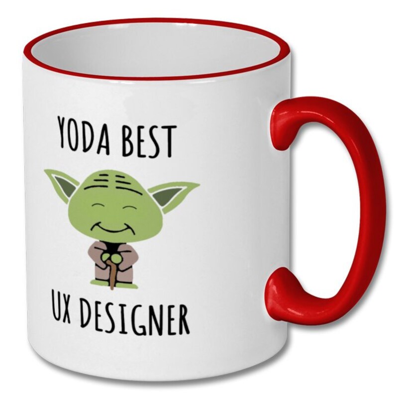 Może przedstawiać: Biały kubek ceramiczny z czerwonym rantem i uchwytem. Kubek przedstawia kresk&oacute;wkową postać Yody z Gwiezdnych Wojen z tekstem "Yoda Best UX Designer".