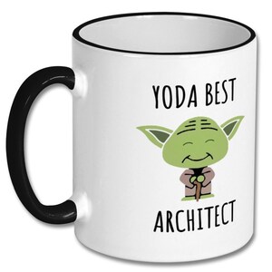 May include: White ceramic coffee mug with a black rim and handle. The mug features a cartoon image of Yoda from Star Wars with the text "Yoda Best Architect".