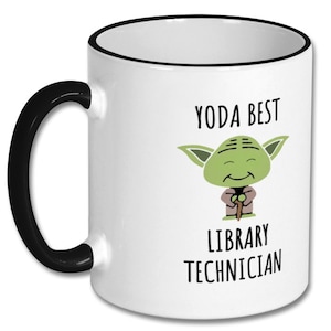 May include: White ceramic coffee mug with a black rim and handle. The mug features a cartoon image of Yoda from Star Wars with the text "Yoda Best Library Technician".