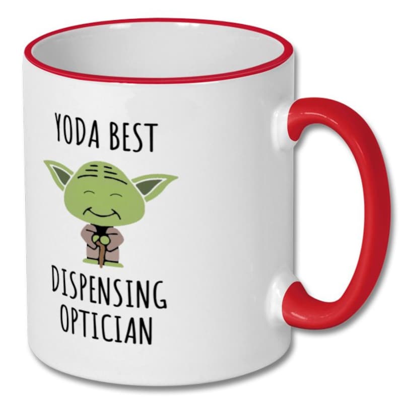 May include: White ceramic mug with a red rim and handle. The mug features a cartoon image of Yoda with the text "Yoda Best Dispensing Optician".